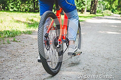 Legs of a cyclist and part of a bicycle on a dirt road Stock Photo