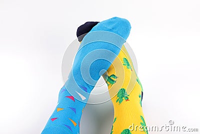 Legs with different a pair of mismatched socks on white background. World Down syndrome day background. Stock Photo