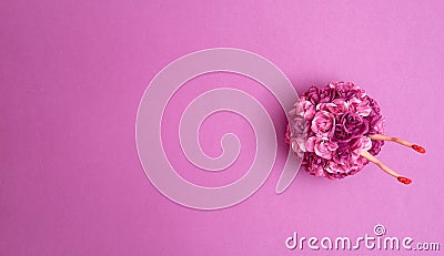 The legs of the doll in a bouquet of artificial two-tone purple roses on a purple background. Text space. Celebrations, weddings, Stock Photo
