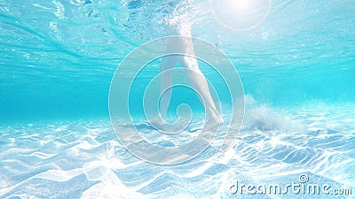 Legs of a girl in the azure transparent sea, underwater Stock Photo