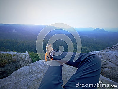 Legs of a man on rock. Hiker resting in boots for mountain Stock Photo