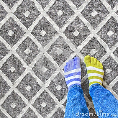 Legs in mismatched socks on gray carpet Stock Photo