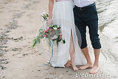 Legs pretty strong young loving couple on the beach over the river Stock Photo