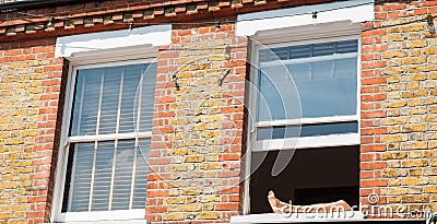 Legs resting on windowsill of open window Stock Photo