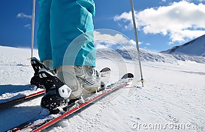 Legs in ski boots, standing on ski Stock Photo