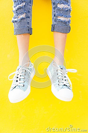 Legs sneakers on yellow background, lifestyle fashion Stock Photo