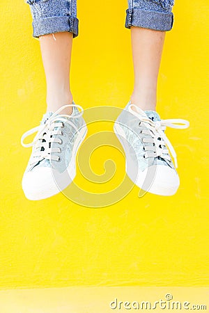 Legs sneakers on yellow background, lifestyle fashion Stock Photo