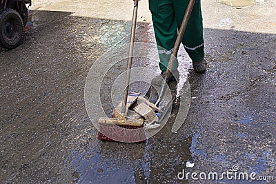 Legs of a urban cleaning worker cleaning the floor wet from the rain at the fair in Sao Joaquim Stock Photo