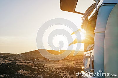 Legs view of happy surfer girl inside minivan at sunset - Young woman having fun on summer vacation - Travel,sport and nature Stock Photo