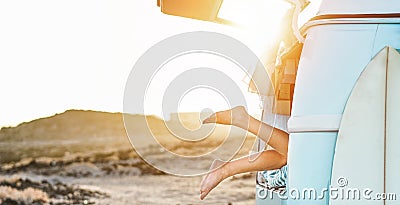 Legs view of happy surfer girl inside minivan at sunset - Young woman having fun on summer vacation - Travel,sport and nature Stock Photo