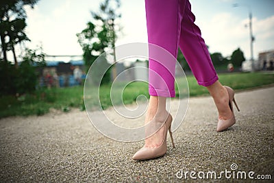 legs of a young girl in heels in step on grass background Stock Photo