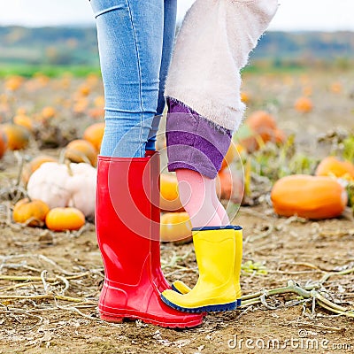 Legs of young woman and her little girl daugher in rainboots. Stock Photo