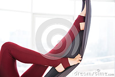 Legs of young woman in leggins using hammock at studio Stock Photo