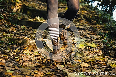 Legs of young woman walking down woodland slope Stock Photo