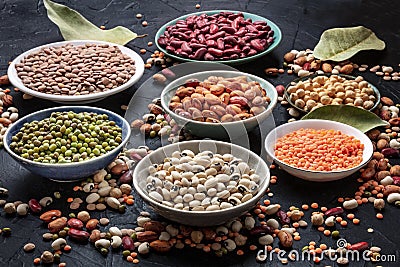 Legumes assortment on a black background. Lentils, soybeans, chickpeas, red kidney beans Stock Photo
