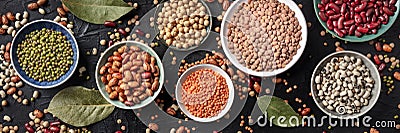 Legumes flat lay panorama, shot from the above on a black background. Lentils, soybeans, chickpeas, red kidney beans Stock Photo