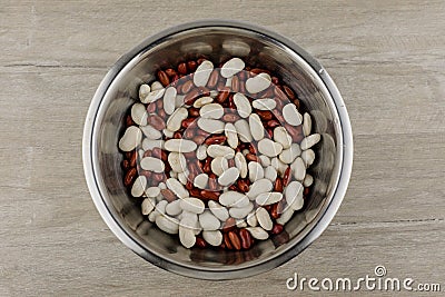 Legumes - a source of protein and micronutrients: red and white beans in a metal plate on the table, in the center; a vegetarian Stock Photo