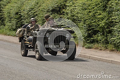 Men dressed in wartime US army soldiers uniform riding in military jeeps during Victory Day Europe Celebration Event at Great Ce Editorial Stock Photo