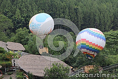 various hot air balloons in the middle of the forest at the maribaya tourist spot in the morning Editorial Stock Photo