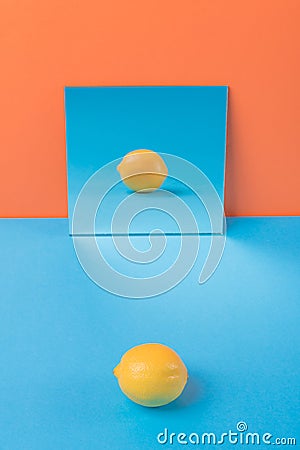 Lemon on blue table over orange background Stock Photo