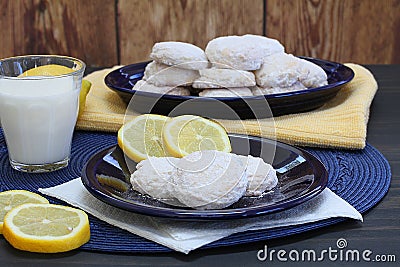 Lemon cookies with powdered sugar with lemons and a glass of mil Stock Photo