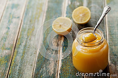 Lemon curd in glass jar on rustic wooden table, traditional fruit cream Stock Photo