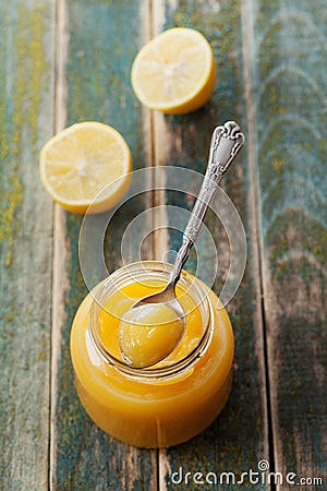 Lemon curd in glass jar on rustic wooden table, traditional fruit cream Stock Photo