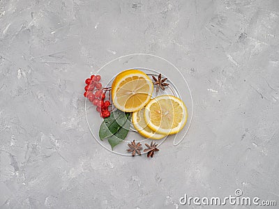 Lemon cut with lemon slices on a transparent plate, decorated with lemon leaves Stock Photo
