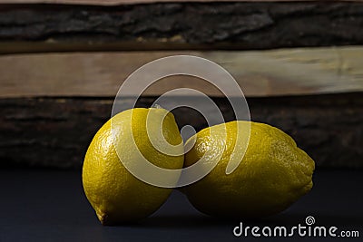 Lemon on a dark background. Two lemons on a wooden background Stock Photo