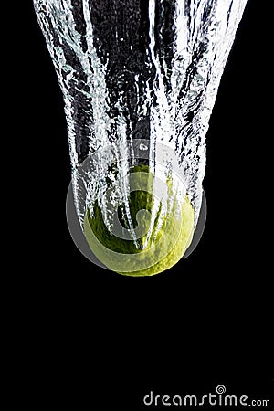 Lemon dropping into water creating splash Stock Photo