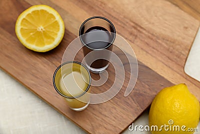 Two shots of lemon ginger and beetroot juice with lemons Stock Photo