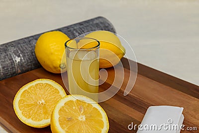 Morning in the kitchen with a glass of fresh lemon and ginger juice with lemon halves. Stock Photo