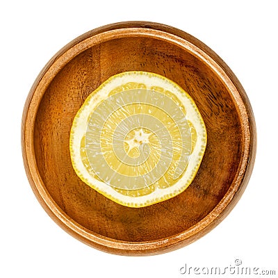 Lemon half, freshly cut ripe yellow citrus fruit in wooden bowl Stock Photo