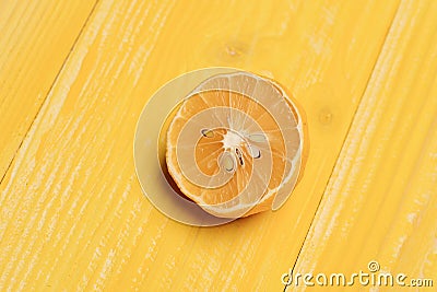 Lemon half on yellow wooden background. Part of dry lemon fruit, close up. Natural nutrition and fruits concep Stock Photo