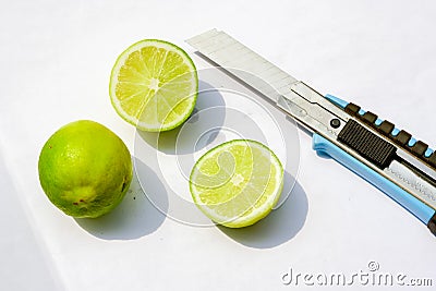 lemon and knife on a white paper.lime cutting Stock Photo