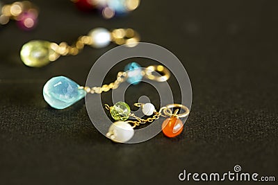 Lemon quartz, ruby, pearl,labradorite,apatite, green chalcedony, blue topaz necklace charm isolated on black background. Stock Photo