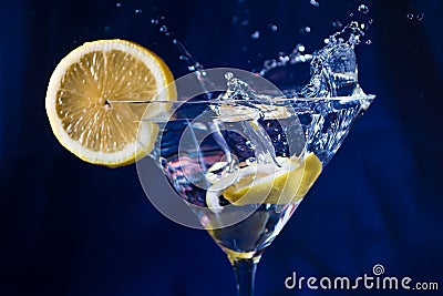 Lemon slice falling into a martini glass cocktail Stock Photo