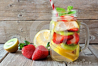 Lemon, strawberry, kiwi detox water in mason jar against wood Stock Photo