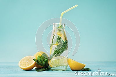 Lemonade drink of soda water, lemon and mint in jar on turquoise background Stock Photo