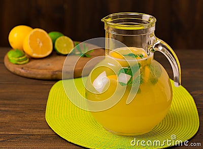 Lemonade with fresh lemon and mint in glass jug on wooden background Stock Photo