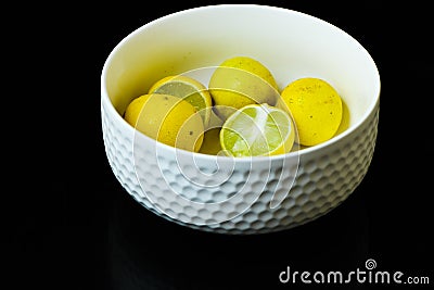 Lemons slices arranged in white cup black isolated background Stock Photo
