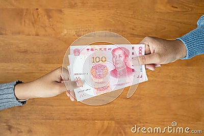 Lend or Giving money concept. Top view hand giving banknote currency Chinese Yuan (CNY or RMB Stock Photo