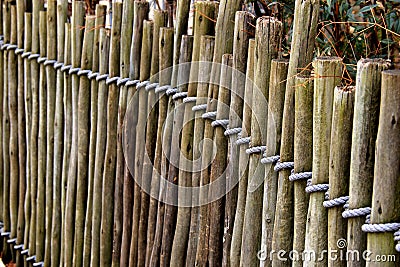 Length of wood posts tied together with heavy rope Stock Photo