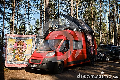 Leningrad Region, Russia - June 2022. Stylish red homemade fiat ducato mobile home with large solar panel on roof. A Editorial Stock Photo
