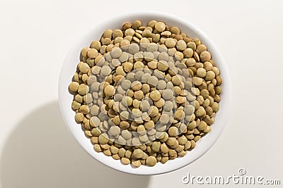 Lentil legume. Top view of grains in a bowl. White background. Stock Photo