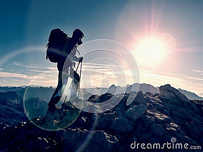 Lens flare defect. Tourist guide on trekking path with poles and backpack. Experienced hiker Stock Photo