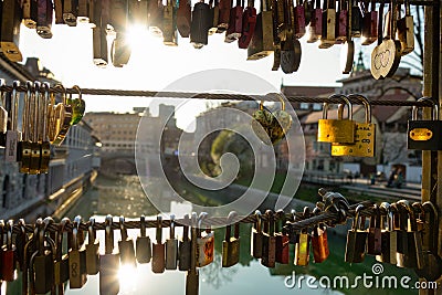 LENS FLARE: Sunbeams shine on lockets locked on a bridge in downtown Ljubljana Editorial Stock Photo