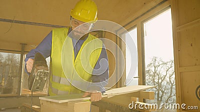 LENS FLARE: Worker building a hardwood house is trimming a gypsum wallboard. Stock Photo
