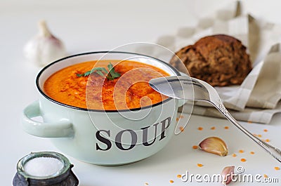 Lentil cream soup in a rustic bowl with piece of black bread on Stock Photo