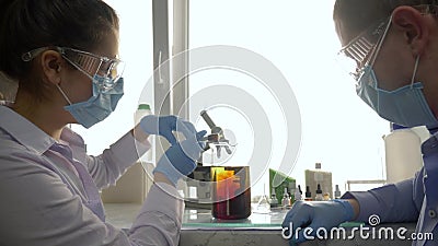 Les scientifiques ajoutent des réactifs à la solution chimique dans un grand verre dans un laboratoire expérimental clips vidéos Les scientifiques ajoutent des réactifs à la solution chimique dans un grand verre dans un laboratoire expérimental clips vidéos